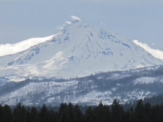 Mount Hood's snow-covered peak rising into a deep blue sky.
