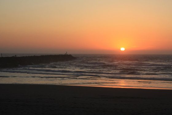 The golden sun setting over the open ocean.