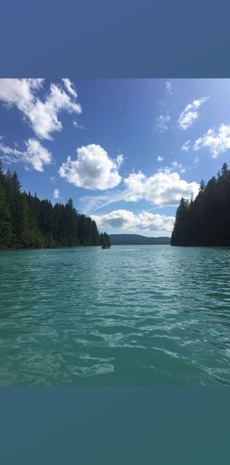 A still alpine lake beneath forested Oregon mountains.